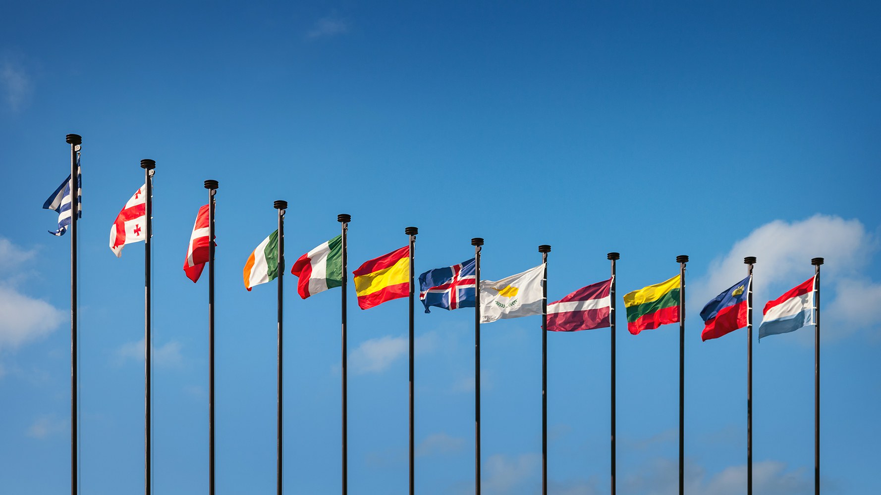 Photo de drapeaux de pays européens flottant au vent sur des hampes de drapeau