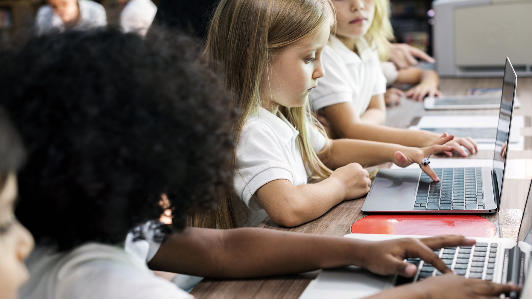 Des filles de l'école primaire travaillent sur des ordinateurs portables